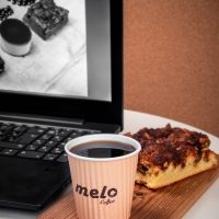 عکس گرافیکی تبلیغاتی برای قهوه میلو شامل دانه قهوه و یک قهوه و یک لپتاپ