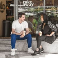 عکس گرافیکی تبلیغاتی برای قهوه میلو شامل یک مرد و زن با لیوان قهوه در دستشان
