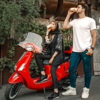 عکس گرافیکی تبلیغاتی برای قهوه میلو شامل یک مرد و زن با لیوان قهوه در دستشان روی یک موتور قرمز